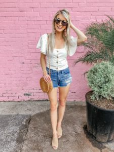 white button up ruffle crop top and round rattan bag